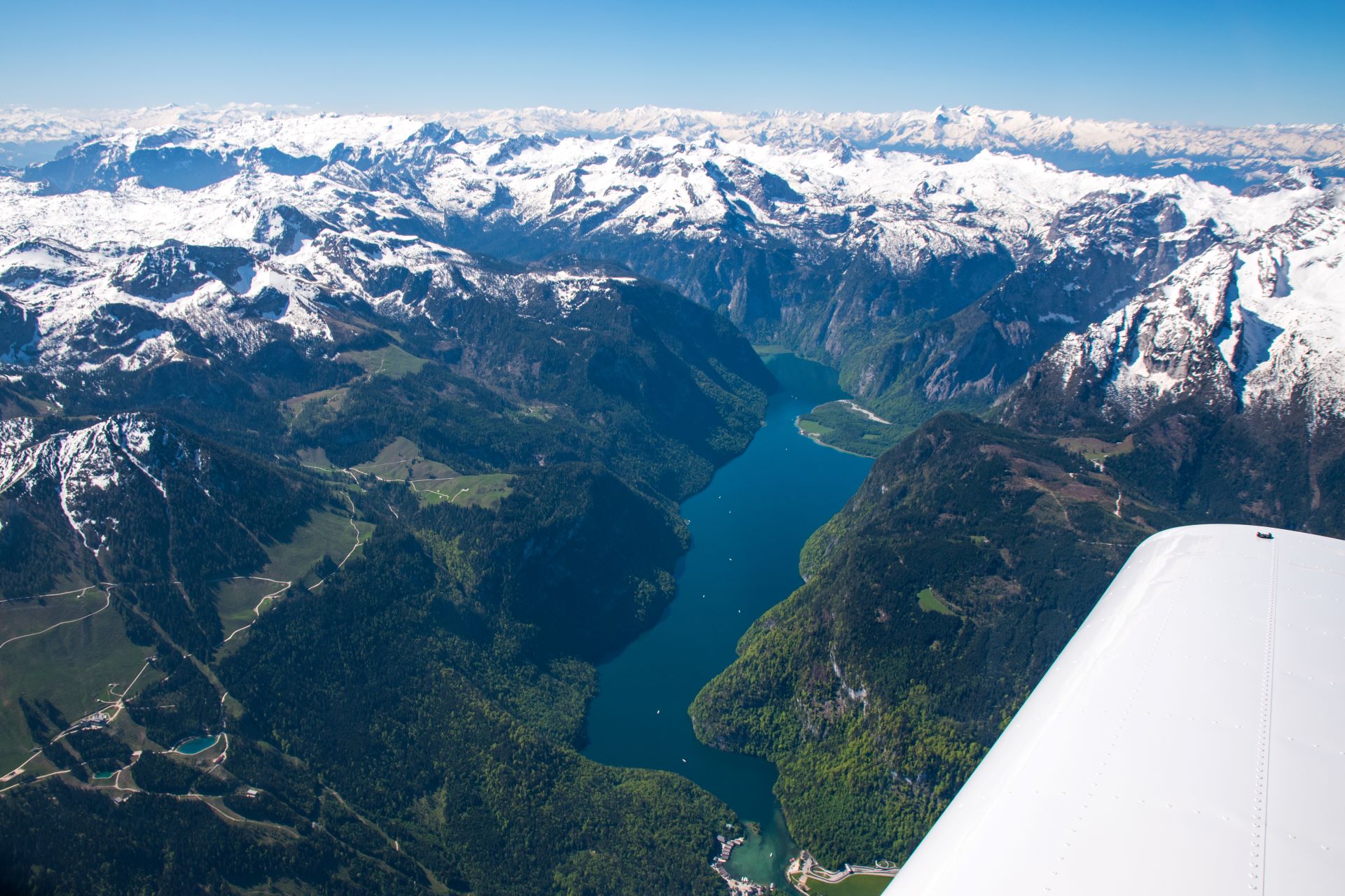 Flugstunde Alpentour, Königssee mit klarem dunkelblauen Wasser